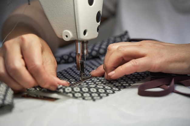 Girl seamstress sew on the sewing machine