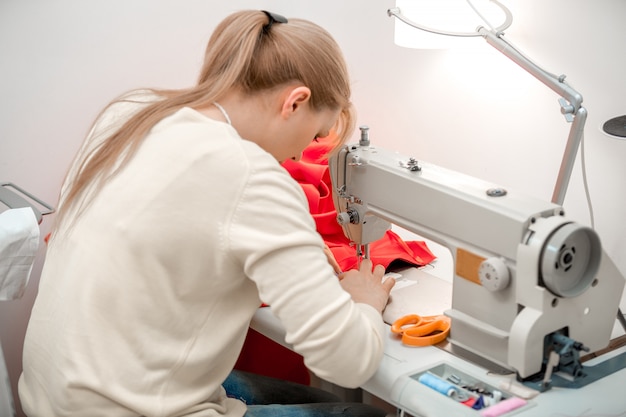 Girl seamstress sew on the sewing machine