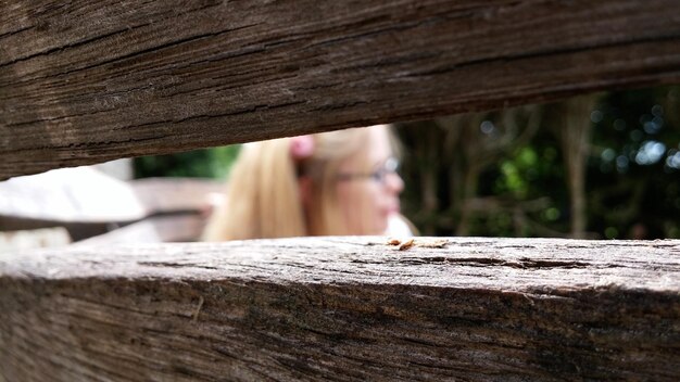 Foto ragazza vista attraverso la recinzione di legno