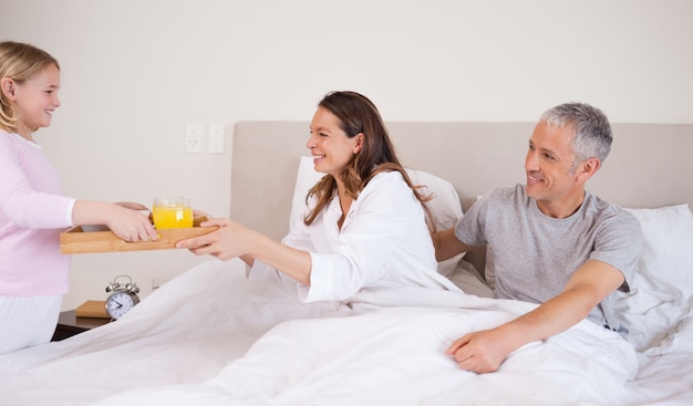 Girl serving breakfast to her parents