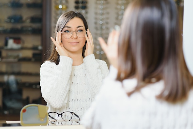 Girl Shopping for Glasses on Sale Season in Optic Store. Stylish customer buying many eyeglasses on discount