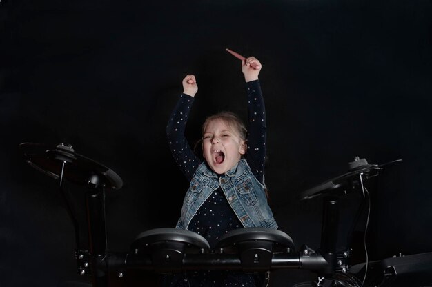 Photo girl shouting while playing drums