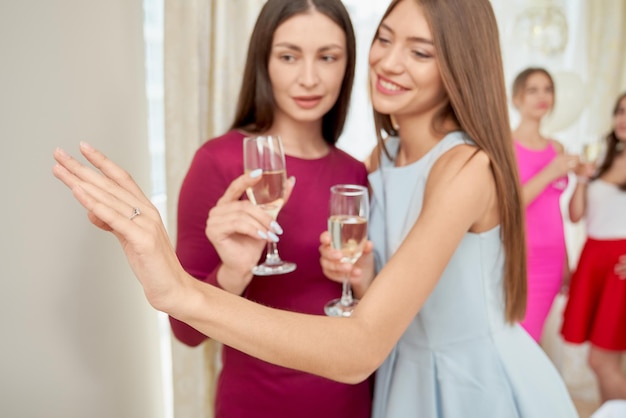 Girl showing engagement ring to friend