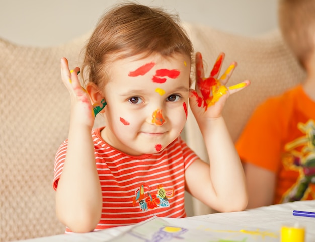 塗られた手を示している女の子。カラフルな絵の具で描かれた手。教育、学校、芸術、painitngのコンセプトです。