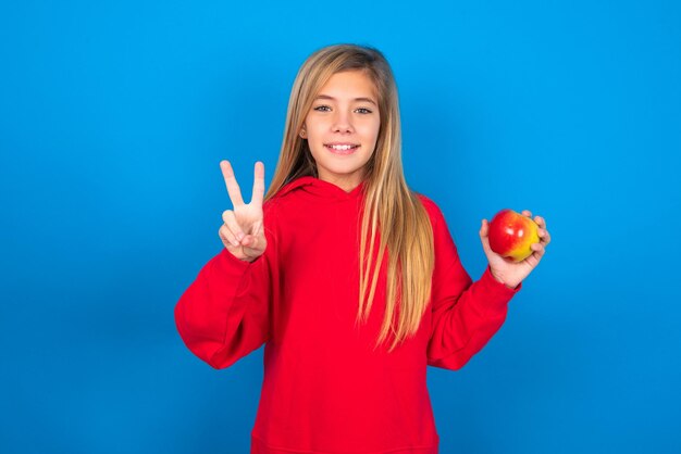 girl showing and pointing up with fingers number two while smiling confident and happy
