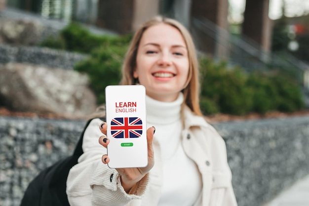 Girl showing smart phone with online learn English concept on screen