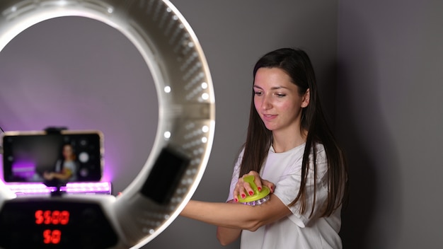 Girl shows a body massager in front of the camera.