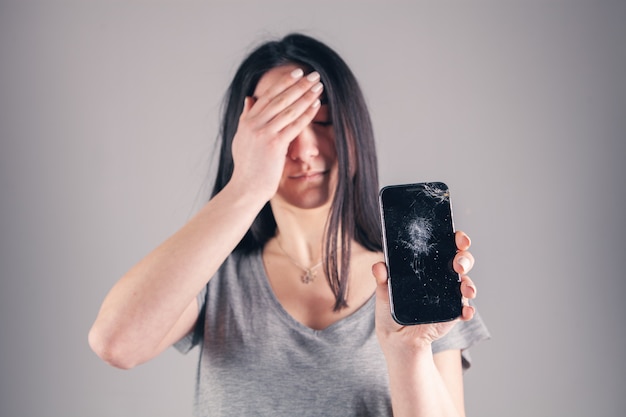 Girl shows a broken phone