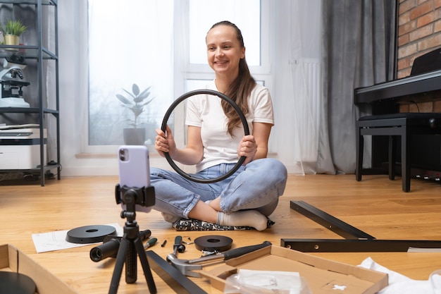 Foto una ragazza mostra i dettagli dei mobili tramite collegamento video utilizzando la fotocamera del suo smartphone