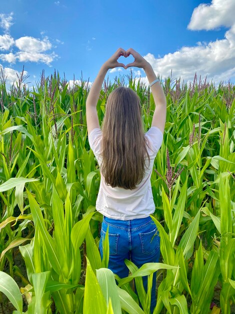 girl shows a heart with her hands on the field