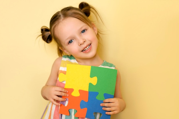 Girl shows the pieces of puzzles put together symbolizing unity and support for people with autism