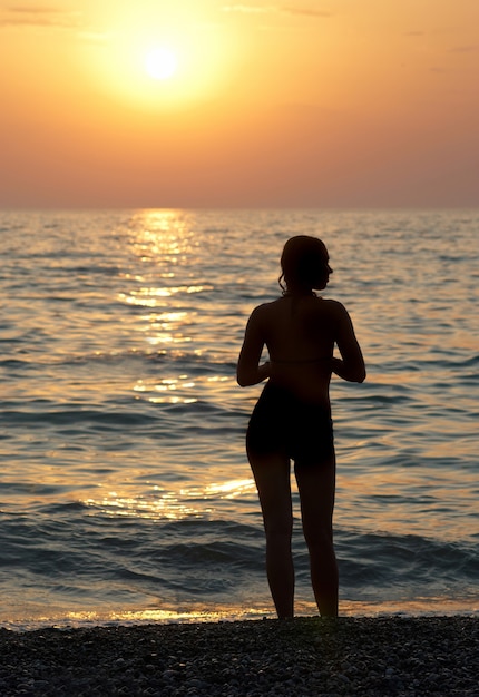 Girl silhouette and sunset on the sea