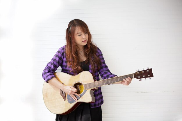 Girl singing on microphone and playing guitar