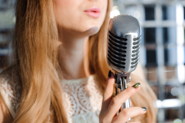 Girl singing in retro microphone