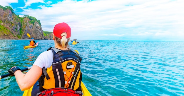 Girl on single kayak or canoe swims at avacha bay in kamchatka peninsula