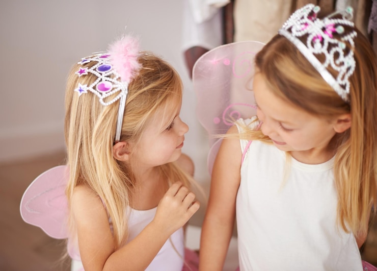 Photo girl sister and play with fairy costume in bedroom of home for dress up fantasy fun or tiara with smile family children and face with princess outfit for bonding fashion or happy with wings