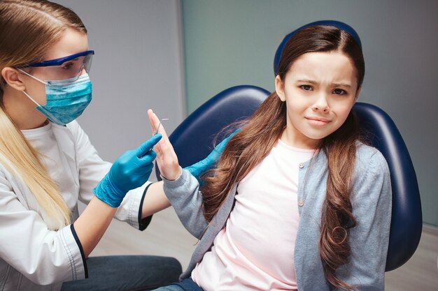 Girl sit in chair in dentist's room