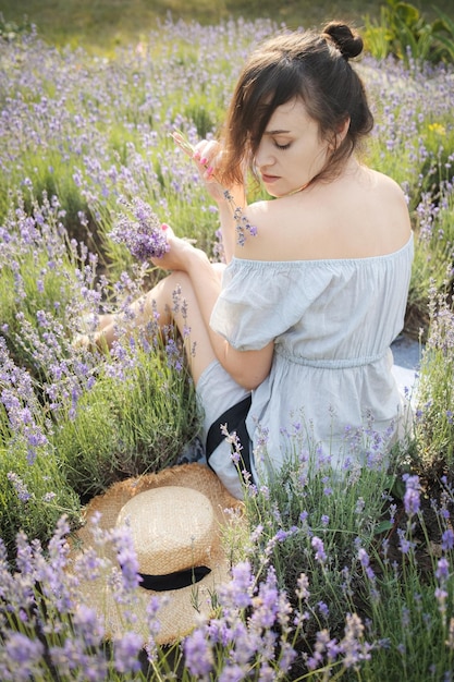 The girl sit in the middle of a lavender field