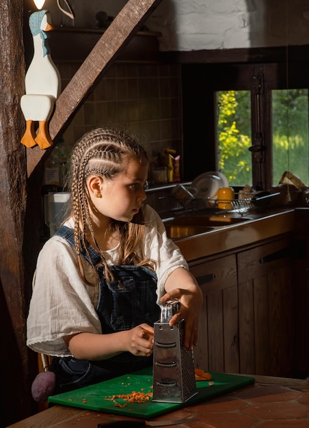 A girl sits in a kitchen with a bottle of water.