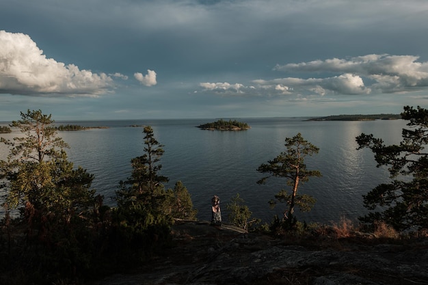 A girl sits on the mountain of the northern beach of Kojonsaari island on Lake Ladoga