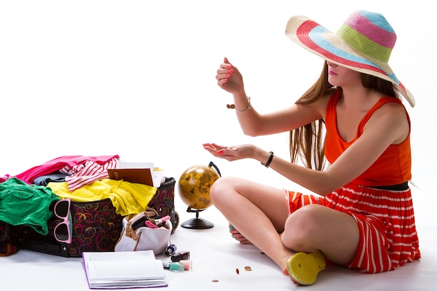 Girl sits near open suitcase coins fall into womans hand pocket money for vacation manicure and stri...