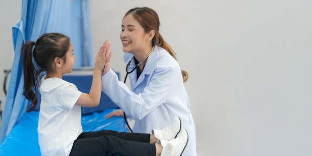 The girl sits on the patient's bed for the doctor