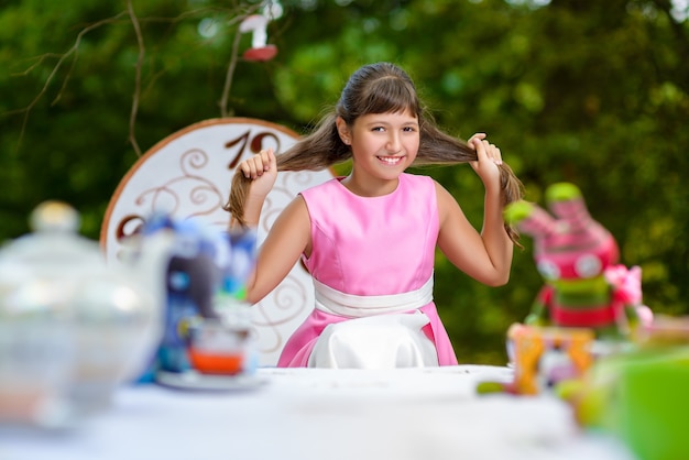 Girl sits at table and holding a cup of tea