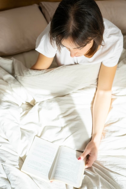 girl sitting on the bed reading a book