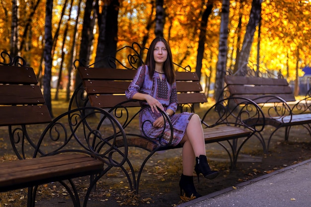 Girl sitting on a bench in the autumn Park