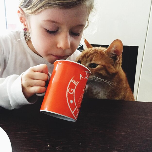 写真 家で猫のそばに座っている女の子