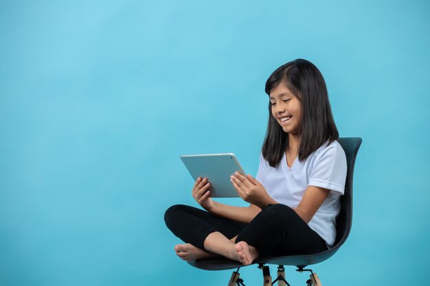 girl sitting on a chair watching tablet