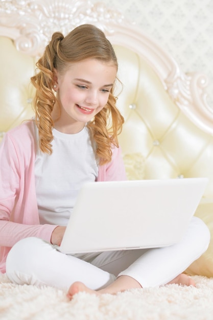 소파에 앉아 현대적인 노트북을 사용하는 소녀