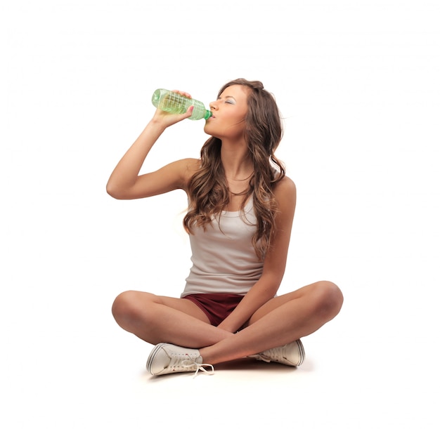 Girl sitting and drinking from a bottle