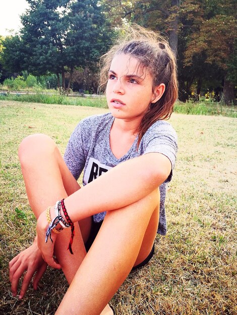 Photo girl sitting on field