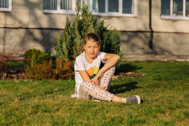 Photo girl sitting on the grass hiding from the sun