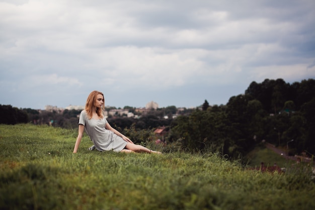 Girl sitting on a green meadow