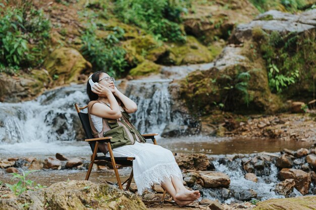 Girl sitting on her stomach listening to music in the forest