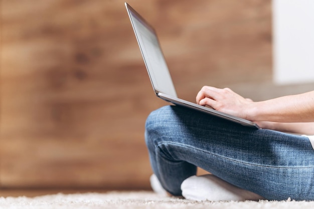 Girl sitting home working and browsing online on laptop