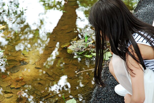 Girl sitting at lakeshore