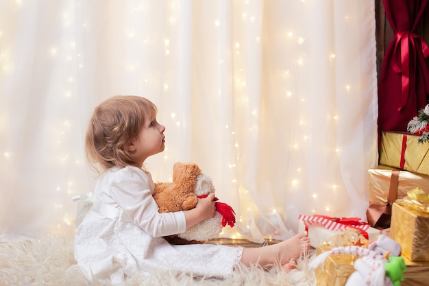 girl sitting looking at Christmas tree