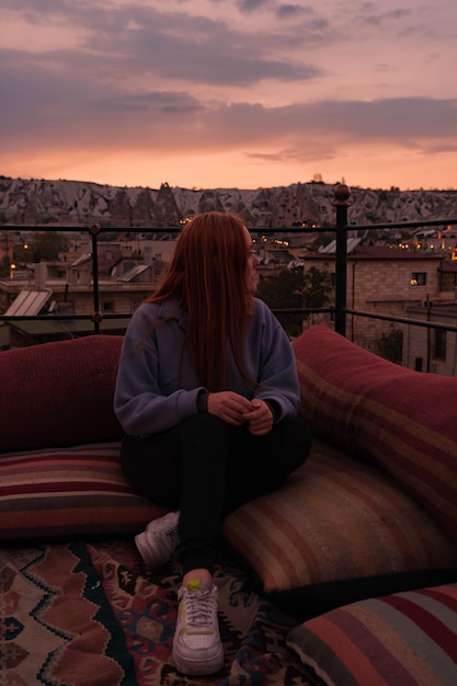 写真 風景を望む屋上に座っている女の子