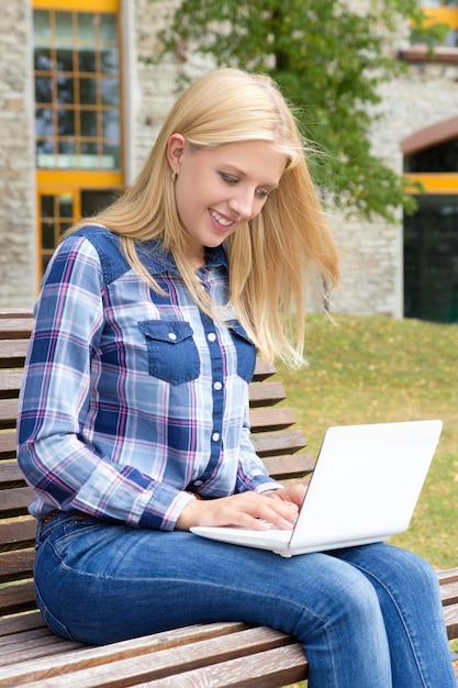 Girl sitting in park with laptop