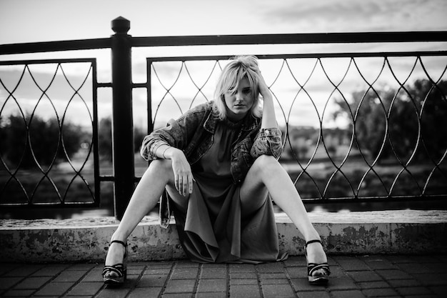 Girl sitting on the sidewalk.