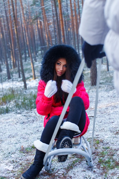 girl sitting on a sledge in the winter forest