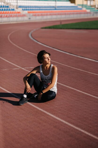 a girl sitting in a stadium on a treadmill