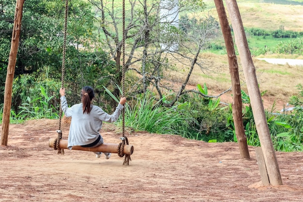 Photo girl sitting on the swing in the forest