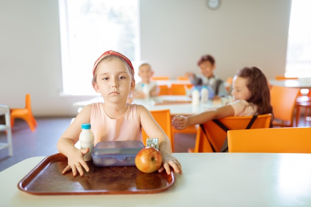 Girl sitting at the table alone while suffering from mockery