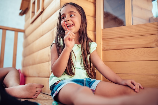 Girl sitting in treehouse and drawing with colored pencils