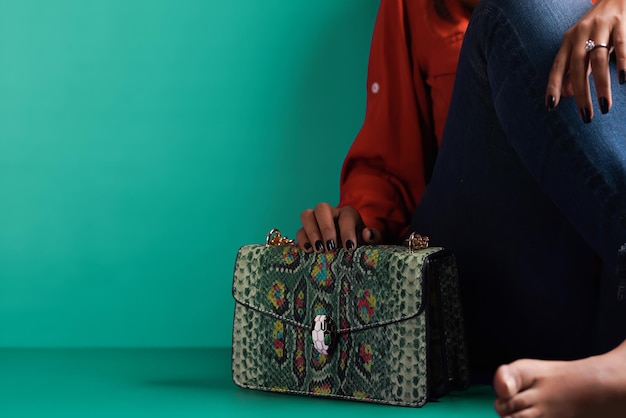 girl  sitting with a bag in green background