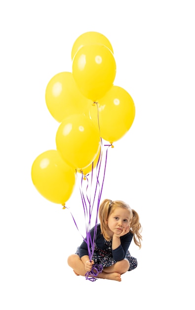 Girl sitting and with colorful balloons.